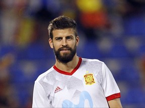 FILE - In this Friday, Oct. 6, 2017 file photo, Spain's Gerard Pique smiles during the team warm up before their World Cup Group G qualifying soccer match against Albania at the Rico Perez stadium in Alicante, Spain. Catalonia's audacious attempt to secede from the rest of Spain represents a threat to one of the world's sporting powers. Catalans have played a key part in establishing Spain as one of the best national soccer teams. The team has qualified for the World Cup in Russia relying on defender Gerard Pique, holding midfielder Sergio Busquets, and left back Jordi Alba. (AP Photo/Alberto Saiz, file)