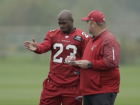 Arizona Cardinals running back Adrian Peterson, left, speaks with Running Backs coach Freddie Kitchens during an NFL training session at the London Irish rugby team training ground in the Sunbury-onThames suburb of south west London, Wednesday, Oct. 18, 2017. The Arizona Cardinals are preparing for an NFL regular season game against the Los Angeles Rams at London's Wembley stadium on Sunday. (AP Photo/Matt Dunham)