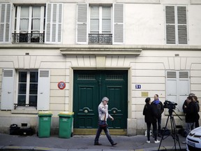 FILE - A Tuesday, Oct. 3, 2017 file photo showing the entrance of an apartment building where police found an explosive device. Three men have been handed preliminary terror-linked charges in the failed attack at a residential building in an upscale Paris neighborhood with gas canisters that failed to ignite. A judicial official said on Saturday, Oct. 7, 2017 that the three were placed under formal investigation late Friday in the mysterious attack attempt.  (AP Photo/Kamil Zihnioglu, File)
