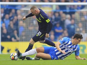 Everton's Wayne Rooney, top, takes the ball from Brighton & Hove Albion's Lewis Dunk during their English Premier League soccer match at the AMEX Stadium in Brighton, England, Sunday Oct. 15, 2017. (Gareth Fuller/PA via AP)