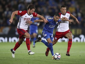 Leicester City's Riyad Mahrez, center, breaks through West Bromwich Albion's Grzegorz Krychowiak and Kieran Gibbs, right, during the English Premier League soccer match at the King Power Stadium, Leicester, England, Monday, Oct. 16, 2017. (Nick Potts/PA via AP)