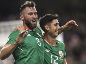 Ireland's Daryl Murphy, left, scores his side's second goal of the game during the 2018 World Cup Group D qualifying soccer match between Republic of Ireland and Moldova  at the Aviva Stadium, Dublin, Friday, Oct. 6, 2017. (Brian Lawless/PA via AP)