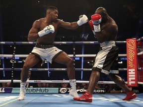 Britain's Anthony Joshua, left, and Cameroon's Carlos Takam fight during the IBF World Heavyweight Title, IBO World Heavyweight Title and WBA Super World Heavyweight Title bout at the Principality Stadium, Cardiff, Wales, Saturday, Oct. 28, 2017. (Nick Potts/PA via AP)