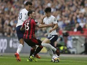 Tottenham's Son Heung-Min, right, and Tottenham's Dele Alli, left, compete for the ball with Bournemouth's Adam Smith during the English Premier League soccer match between Tottenham Hotspur and AFC Bournemouth at Wembley stadium in London, Saturday Oct. 14, 2017. (AP Photo/Tim Ireland)