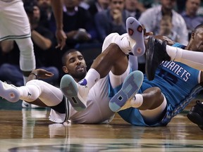 Boston Celtics guard Kyrie Irving, left, and Charlotte Hornets center Dwight Howard, right, become  entangled while chasing a loose ball during the first quarter of an NBA preseason basketball game in Boston, Monday, Oct. 2, 2017. (AP Photo/Charles Krupa)