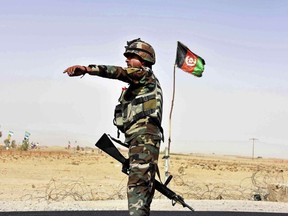 An Afghan National Army soldier directs a vehicle to stop at a checkpoint on the way to Zhari district, where the Maiwand army base is located, in Kandahar, Afghanistan, Thursday, Oct. 19, 2017. The Taliban have killed at least 58 Afghan security forces in a wave of attacks across the country, including an assault that nearly wiped out the Maiwand camp in the southern Kandahar province. (AP Photo/Massoud Hossaini)