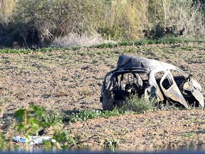 The wreckage of the car of investigative journalist Daphne Caruana Galizia lies next to a road in the town of Mosta, Malta, Monday, Oct. 16, 2017. Malta's prime minister says a car bomb has killed an investigative journalist on the island nation. Prime Minister Joseph Muscat said the bomb that killed reporter Daphne Caruana Galizia exploded Monday afternoon as she left her home in a town outside Malta's capital, Valetta. (AP Photo/Rene Rossignaud)