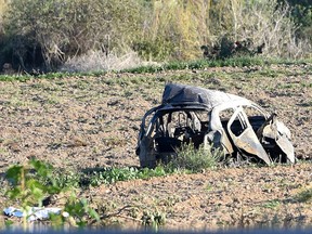 The wreckage of the car of investigative journalist Daphne Caruana Galizia lies next to a road in the town of Mosta, Malta, Monday, Oct. 16, 2017.