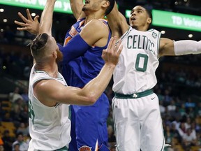New York Knicks' Enes Kanter, center, shoots against Boston Celtics' Aron Baynes, left, and Jayson Tatum (0) during the first quarter of an NBA basketball game in Boston, Tuesday, Oct. 24, 2017. (AP Photo/Michael Dwyer)