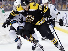 San Jose Sharks' Ryan Carpenter (40) battles Boston Bruins' Kevan Miller (86) for the puck during the first period of an NHL hockey game in Boston, Thursday, Oct. 26, 2017. (AP Photo/Michael Dwyer)