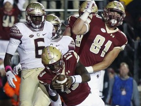 Boston College quarterback Anthony Brown (13) scores in front of Florida State linebacker Matthew Thomas (6) during the half of an NCAA college football game in Boston, Friday, Oct. 27, 2017. (AP Photo/Michael Dwyer)