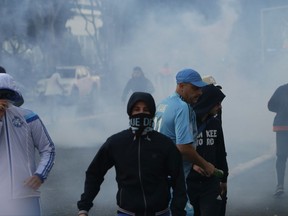 Supporters fight with the police before the League One soccer match between Marseille and Paris Saint-Germain, at the Velodrome stadium, in Marseille, southern France, Sunday, Oct. 22, 2017. (AP Photo/Claude Paris)