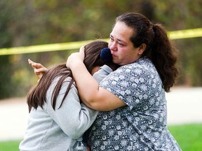 Maria Ortiz consoles her Grade 5 daughter, Crystal Godinez, after she was evacuated from Castle View Elementary School in Riverside, Calif., on Tuesday, Oct. 31, 2017, as a result of a hostage-taking.