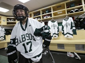 Coleman Walsh, 10, of Walpole, Mass., left, steps out of the Babson College men's ice hockey locker room following ceremonies held to sign an official letter of intent, Tuesday, Oct. 10, 2017, in Wellesley, Mass., to induct Walsh to the team. Since birth, Coleman has been fighting Williams syndrome, a developmental disorder that affects numerous parts of the body. The induction was organized by Team IMPACT, a national nonprofit that connects colleges with youngsters dealing with debilitating or life-threatening illness. (AP Photo/Steven Senne)
