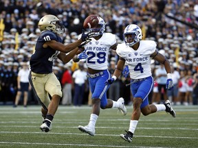 Navy running back Malcolm Perry, left, catches a pass as he runs for a touchdown in front of Air Force defensive backs Kyle Floyd, center, and James Jones in the first half of an NCAA college football game in Annapolis, Md., Saturday, Oct. 7, 2017. (AP Photo/Patrick Semansky)