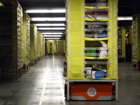 In this Aug. 3, 2017, photo, robots move shelves full of products at an Amazon fulfillment center in Baltimore. While jobs have been lost in brick-and-mortar stores, many more have been gained from e-commerce and warehousing. Amazon accounts for much of the additional employment. (AP Photo/Patrick Semansky)