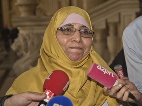 Zoulika Azirin the mother of the Merah brothers leaves the courthouse in Paris, France, Wednesday, Oct. 18, 2017. The mother of Islamic extremist Mohammed Merah testifies in the trial into the 2012 killings of Jewish schoolchildren and soldiers in southern France. (AP Photo/Michel Euler)