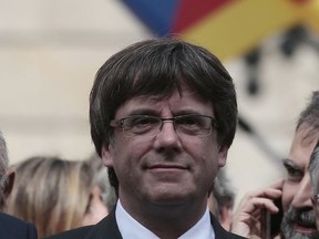 Catalan President Carles Puigdemont, attends during a protest called by pro-independence outside of the Palau Generalitat in Barcelona, Spain, Monday, Oct. 2, 2017. Catalonia's government will hold a closed-door Cabinet meeting Monday to discuss the next steps in its plan to declare independence from Spain following a disputed referendum marred by violence. (AP Photo/Manu Fernandez),