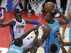 Detroit Pistons guard Reggie Jackson (1) passes the ball while defended by Charlotte Hornets center Dwight Howard (12) and forward Marvin Williams during the first half of an NBA basketball game, Wednesday, Oct. 18,2017, in Detroit. (AP Photo/Carlos Osorio)