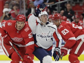 Washington Capitals left wing Jakub Vrana (13) skates between Detroit Red Wings defensemen Jonathan Ericsson (52) and Trevor Daley (83) during the first period of an NHL hockey game, Friday, Oct. 20, 2017, in Detroit. (AP Photo/Carlos Osorio)