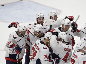 Washington Capitals left wing Alex Ovechkin (8) is congratulated by teammates after scoring the winning goal in overtime of an NHL hockey game against the Detroit Red Wings, Friday, Oct. 20, 2017, in Detroit. (AP Photo/Carlos Osorio)