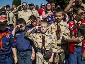 FILE - In this Monday, May 29, 2017 file photo, Boy Scouts and Cub Scouts salute during a Memorial Day ceremony in Linden, Mich. On Wednesday, Oct. 11, 2017, the Boy Scouts of America Board of Directors unanimously approved to welcome girls into its Cub Scout program and to deliver a Scouting program for older girls that will enable them to advance and earn the highest rank of Eagle Scout. (Jake May/The Flint Journal - MLive.com via AP)