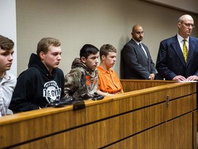 From left to right, Trevor Gray, 15, Alexzander Miller, 15, Mikadyn Payne, 16, and Kyle Anger, 17, all of Clio, Mich., appear for their arraignment in front of Judge William Crawford on Tuesday, Oct. 24, 2017, in Genesee County District Court in downtown Flint, Mich. Along with Clio resident Mark Sekelsky, 16, not pictured, the teenagers are charged with second-degree murder in a rock-throwing incident on Interstate 75. (Terray Sylvester /The Flint Journal-MLive.com via AP)
