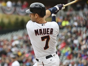 Minnesota Twins hitter Joe Mauer hits an RBI-double against the Detroit Tigers in the first inning of a baseball game, Sunday Oct. 1, 2017, in Minneapolis. (AP Photo/John Autey)