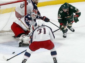 Columbus Blue Jackets goalie Sergei Bobrovsky, left, of Russia, stops a shot as Minnesota Wild's Luke Kunin, right, looked for a rebound during the first period of an NHL hockey game Saturday, Oct. 14, 2017, in St. Paul, Minn. (AP Photo/Jim Mone)