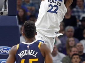 Minnesota Timberwolves' Andrew Wiggins (22) dunks as Utah Jazz's Donovan Mitchell looks on during the first half of an NBA basketball game Friday, Oct. 20, 2017, in Minneapolis. (AP Photo/Jim Mone)