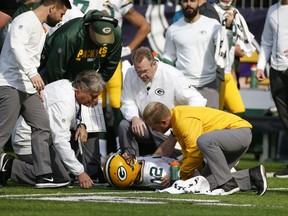 Green Bay Packers quarterback Aaron Rodgers (12) is attended to by medical staff after being hit by Minnesota Vikings outside linebacker Anthony Barr (55) in the first half of an NFL football game in Minneapolis, Sunday, Oct. 15, 2017. (AP Photo/Bruce Kluckhohn)