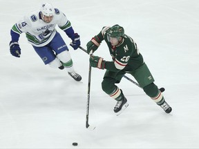 Minnesota Wild's Ryan Suter (20) controls the puck against Vancouver Canucks' Derek Dorsett (8) in the first period of an NHL hockey game Tuesday, Oct. 24, 2017, in St. Paul, Minn. (AP Photo/Stacy Bengs)