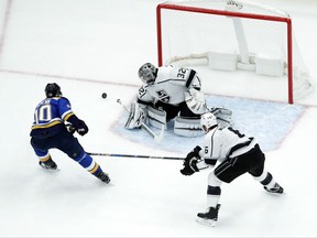 Los Angeles Kings goalie Jonathan Quick (32) deflects a shot from St. Louis Blues' Brayden Schenn, left, as Kings' Jake Muzzin, right, gets in on the play during the first period of an NHL hockey game Monday, Oct. 30, 2017, in St. Louis. (AP Photo/Jeff Roberson)