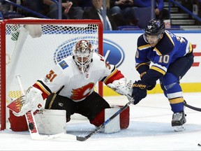 Calgary Flames goalie Eddie Lack, of Sweden, deflects a puck away from St. Louis Blues' Brayden Schenn (10) during the second period of an NHL hockey game Wednesday, Oct. 25, 2017, in St. Louis. (AP Photo/Jeff Roberson)
