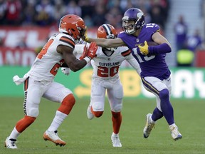 Minnesota Vikings wide receiver Adam Thielen, right, holds off Cleveland Browns' Ibraheim Campbell, left, and Briean Boddy-Calhoun (20) during the first half of an NFL football game at Twickenham Stadium in London, Sunday Oct. 29, 2017. (AP Photo/Tim Ireland)