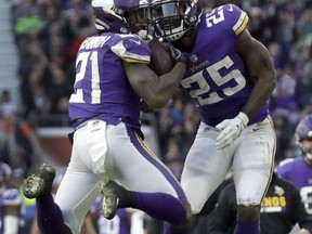 Minnesota Vikings running back Jerick McKinnon (21) is congratulated by teammate Latavius Murray after scoring on a 2-point conversion during the second half of an NFL football game against Cleveland Browns at Twickenham Stadium in London, Sunday Oct. 29, 2017. The Vikings won 33-16. (AP Photo/Matt Dunham)