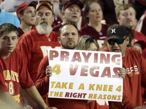 A fan holds a Praying for Vegas sign before an NFL football game between the Kansas City Chiefs and the Washington Redskins in Kansas City, Mo., Monday, Oct. 2, 2017. (AP Photo/Charlie Riedel)