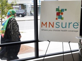 In this Oct. 26, 2017, photo, a woman walks past the Briva Health enrollment office for MNsure, Minnesota's insurance marketplace, in Minneapolis. Health care consumers in most of the country are encountering a world of confusion and chaos as the open enrollment period to sign up for coverage approaches. The outlook is decidedly different in the 12 states that operate their own marketplaces. California, Colorado, Minnesota and other states that operate autonomous exchanges are pulling out all the stops to inform consumers. Briva Health is MNsure's largest enrollment partner. (AP Photo/Jim Mone)