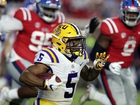 LSU running back Derrius Guice (5) runs for a first down past Mississippi defenders in the first half of an NCAA college football game in Oxford, Miss., Saturday, Oct. 21, 2017. (AP Photo/Rogelio V. Solis)