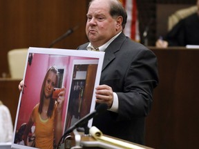 Panola County District Attorney John Champion holds an enlargement of a selfie taken by the late Jessica Chambers, as he presents his closing arguments to the jury, Sunday, Oct. 15, 2017, in Batesville, Miss., in the capital murder case against Quinton Tellis. Tellis is charged with burning Chambers to death almost three years earlier. Tellis pleaded not guilty and did not testify during the trial. (AP Photo/Rogelio V. Solis, Pool)