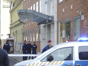 Police officers stand in front of the entrance of the Church of Scientology of Budapest headquarters in Vaci Road in Budapest, Hungary, Wednesday, Oct. 18, 2017. Hungarian police say they are carrying out a search at the church. Police said the search by members of the National Investigation Bureau is related to an investigation into the suspected misuse of personal information and other crimes, but will not be releasing more information because the inquiry was ongoing. (Zoltan Mihadak/MTI via AP)