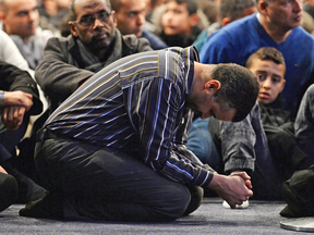 People pray in February at funeral services for three of the victims of the deadly shooting at the Quebec Islamic Cultural Centre in Quebec City.