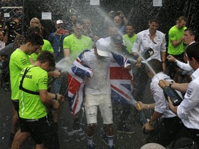 Mercedes driver Lewis Hamilton, of Britain, celebrates with his team at the pit lane after the Formula One Mexico Grand Prix auto race at the Hermanos Rodriguez racetrack in Mexico City, Sunday, Oct. 29, 2017. Hamilton won his fourth career Formula One season championship on Sunday with a ninth-place finish at the Mexican Grand Prix in a race won by Red Bull's Max Verstappen.(AP Photo/Marco Ugarte)
