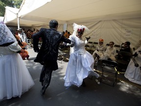 Revelers dance as they wait for the start of a Day of the Dead parade to begin along Mexico City's main Reforma Avenue, Saturday, Oct. 28, 2017. Mexico's capital is holding its Day of the Dead parade, an idea actually born out of the imagination of a scriptwriter for the James Bond movie "Spectre." (AP Photo/Eduardo Verdugo)