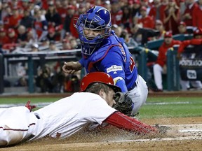 Chicago Cubs catcher Willson Contreras (40) tags out Washington Nationals' Trea Turner (7) at home on a infield grounder by Bryce Harper during the first inning of Game 5 of baseball's National League Division Series, at Nationals Park, Thursday, Oct. 12, 2017, in Washington. (AP Photo/Alex Brandon)