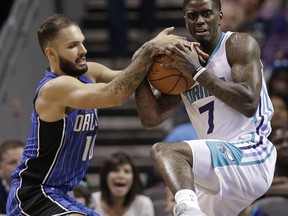 Charlotte Hornets' Dwayne Bacon (7) and Orlando Magic's Evan Fournier (10) battles for a rebound during the first half of an NBA basketball game in Charlotte, N.C., Sunday, Oct. 29, 2017. (AP Photo/Chuck Burton)