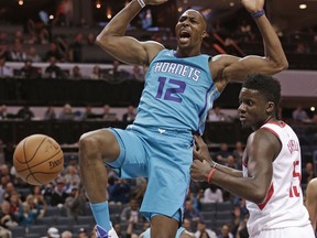 Charlotte Hornets' Dwight Howard (12) reacts to his dunk against Houston Rockets' Clint Capela (15) during the first half of an NBA basketball game in Charlotte, N.C., Friday, Oct. 27, 2017. (AP Photo/Chuck Burton)