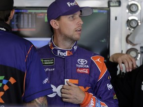 Denny Hamlin looks from the garage before practice for Sunday's NASCAR Cup Series auto race at Charlotte Motor Speedway in Concord, N.C., Friday, Oct. 6, 2017. (AP Photo/Chuck Burton)