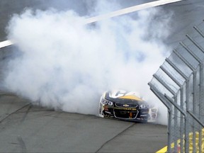 Smoke billows from Ryan Newman's race car after a crash and fire during a NASCAR Cup Series auto race at Charlotte Motor Speedway in Concord, N.C., Sunday, Oct. 8, 2017. (AP Photo/Mike McCarn)