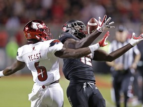 Louisville's Russ Yeast (6) defends as North Carolina State's Stephen Louis (12) reaches for a pass during the first half of an NCAA college football game in Raleigh, N.C., Thursday, Oct. 5, 2017. The pass was complete. (AP Photo/Gerry Broome)